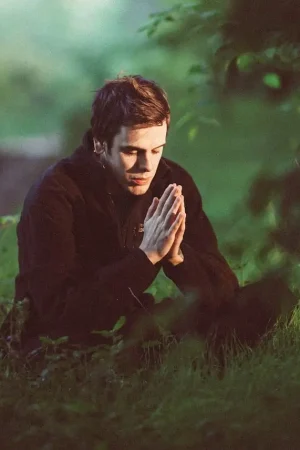 Hombre meditando en medio de un bosque verde